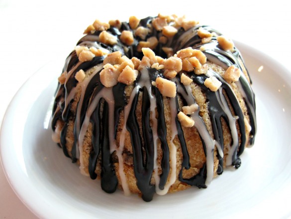 One Vanilla Bean Mini-Bundt Cakes with Chocolate-Toffee Crunch on a white plate.