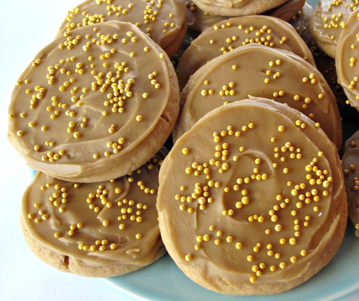 Closeup of cookies on a blue plate, showing the thick swirled caramel icing.