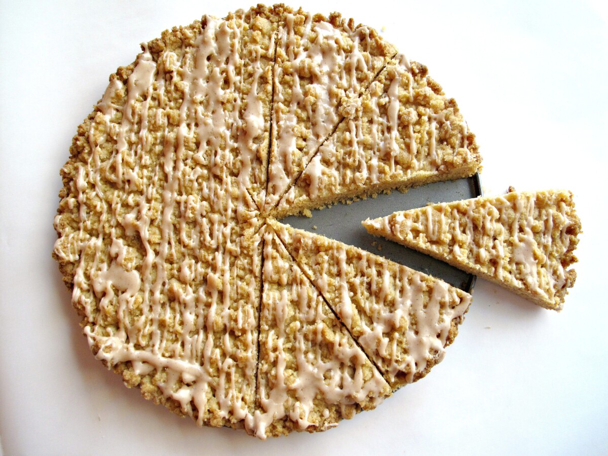 Streusel Cookies baked in a cake pan, drizzled with icing and sliced into wedges.