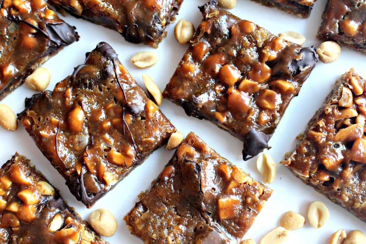 Caramel Chocolate Peanut Bars with peanuts showing through the shiny caramel top.