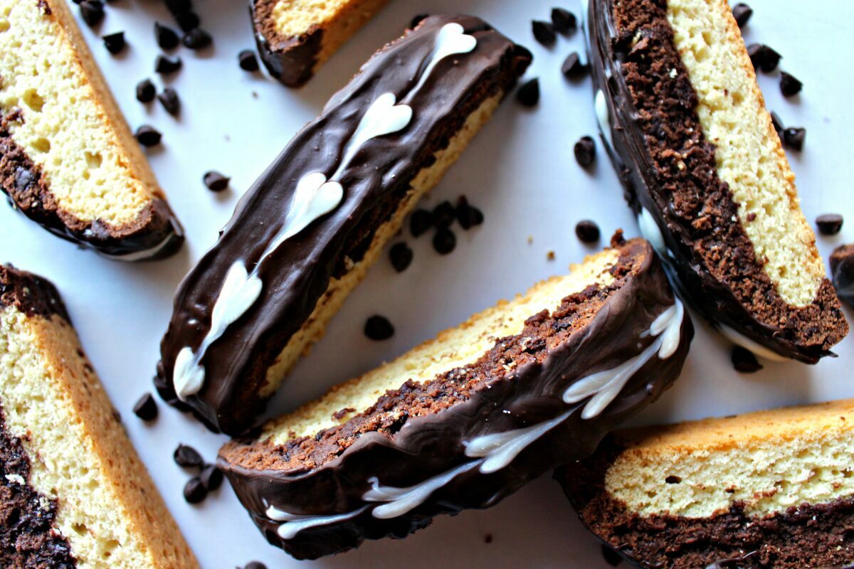 Closeup of biscotti tops decorated with dark chocolate and white chocolate hearts.