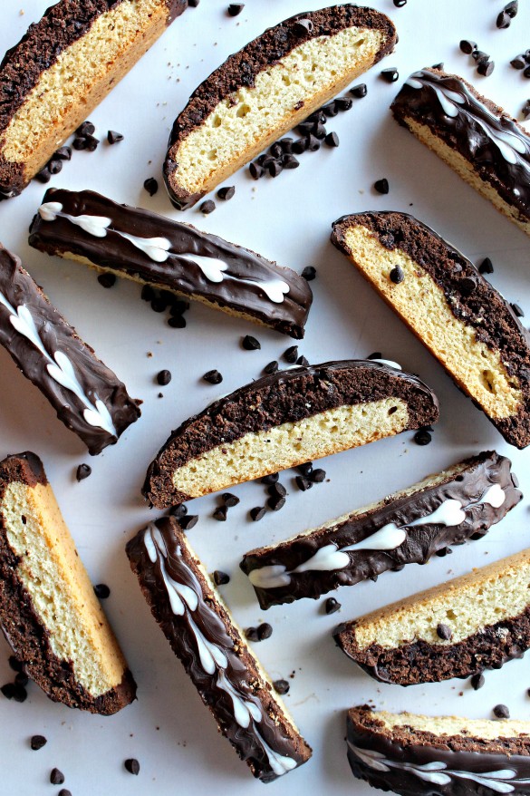 Black and White Biscotti has a bottom layer of vanilla cookie and a top layer of chocolate cookie. Dark chocolate is spread on the top of each biscotti and decorated with white chocolate hearts.
