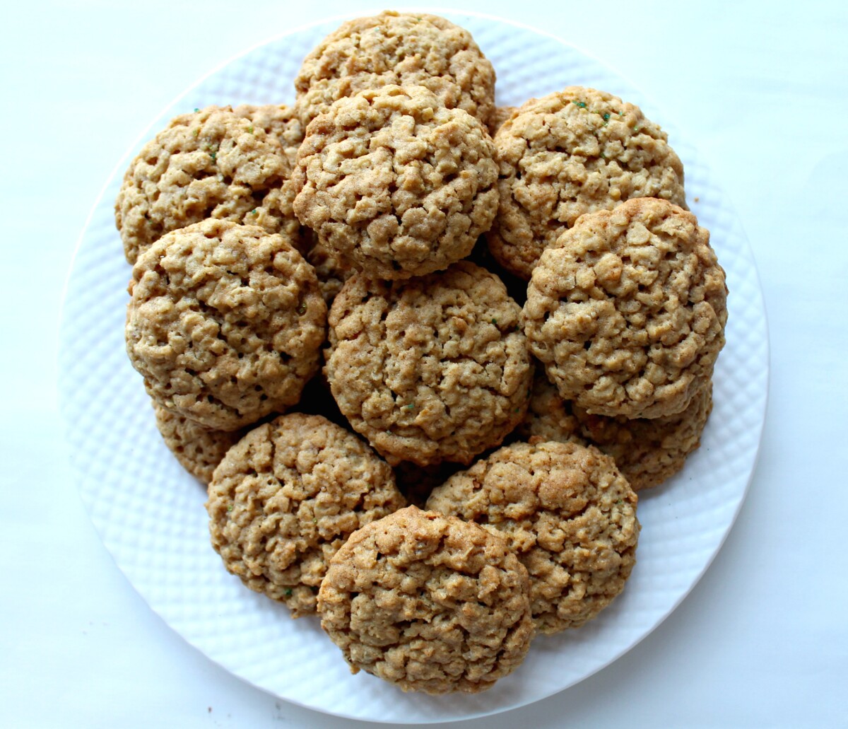 A pile of cookies on a white serving plate.