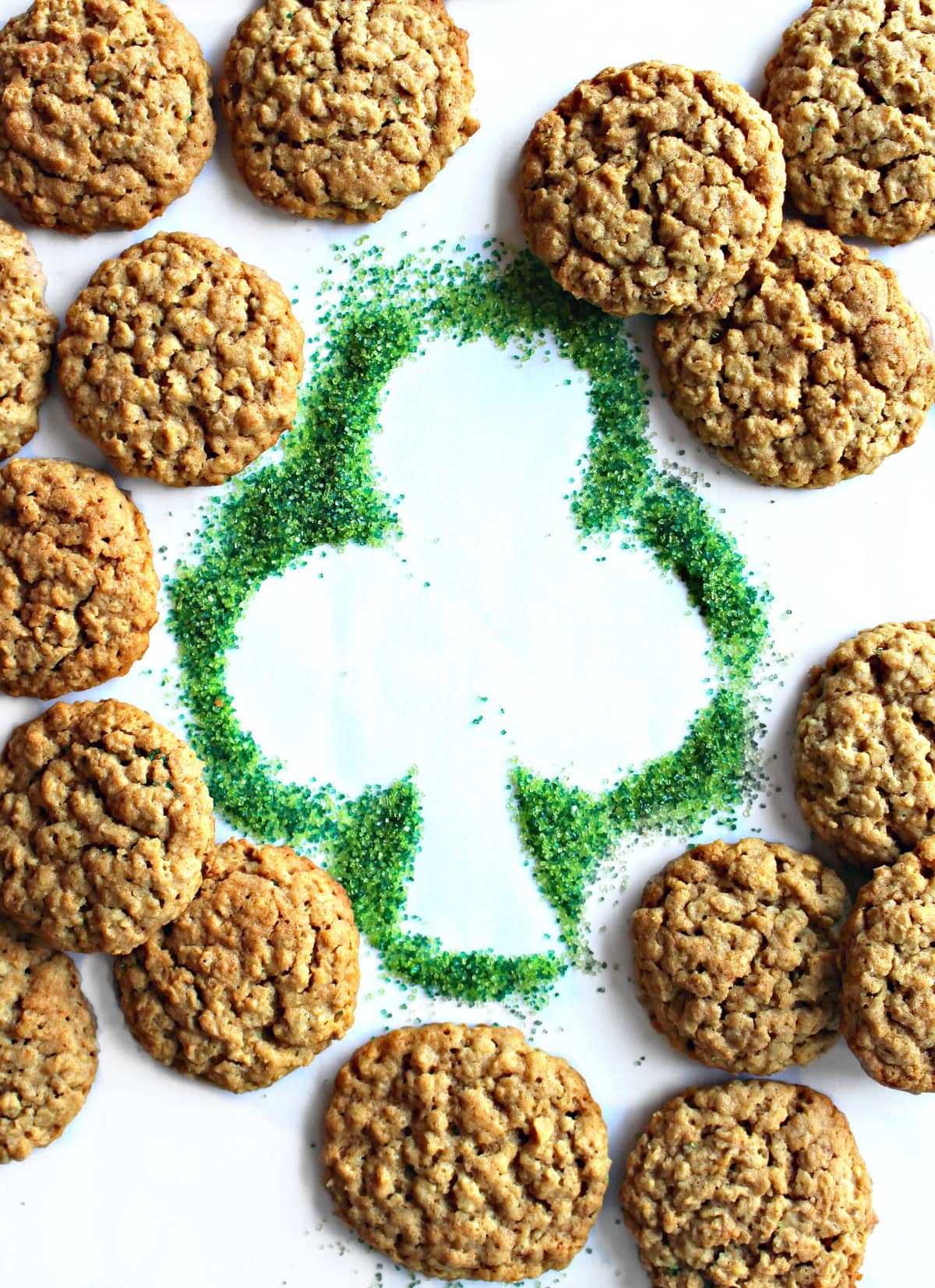 Steel cut oatmeal cookies surrounding a shamrock shape made with green sugar.