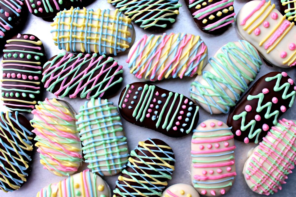 Decorated Milano Cookies Easter Eggs in a variety of pattern made with melted pastel colored chocolate.