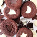 Chocolate sandwich cookies with cutouts on top.