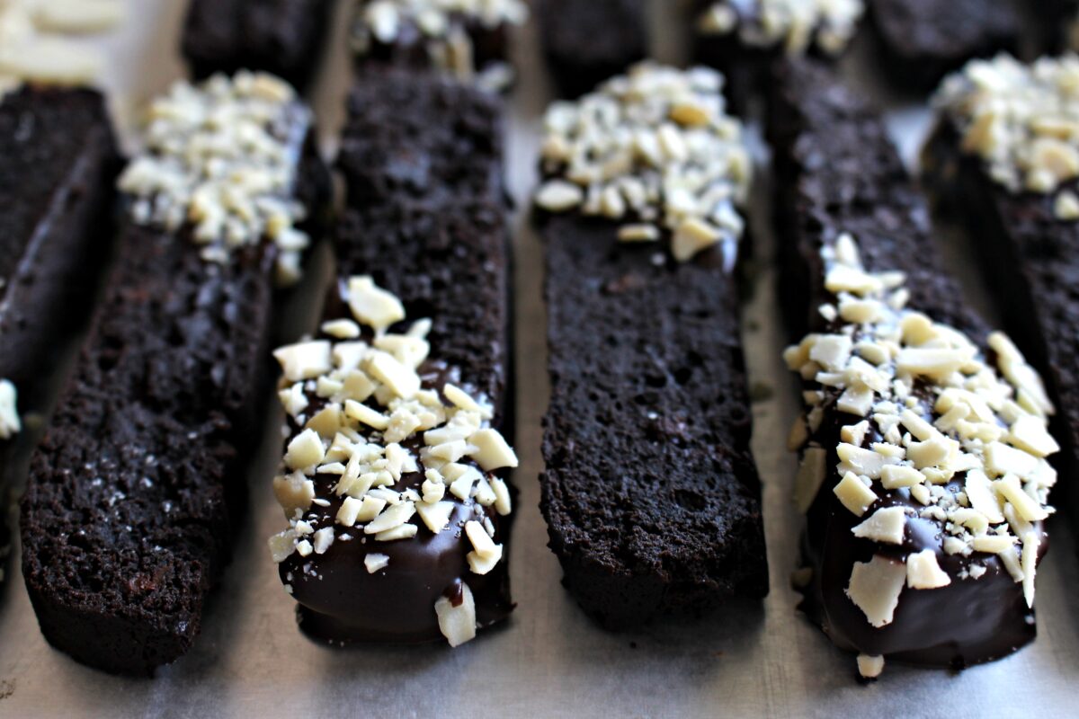 Closeupof biscotti with two plain and 2  chocolate dipped and coated in almond bits.