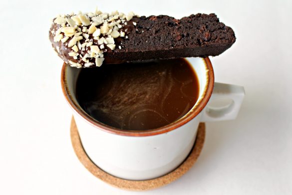 1 Double Chocolate Pasover Biscotti balanced on the edge of a mug of coffee