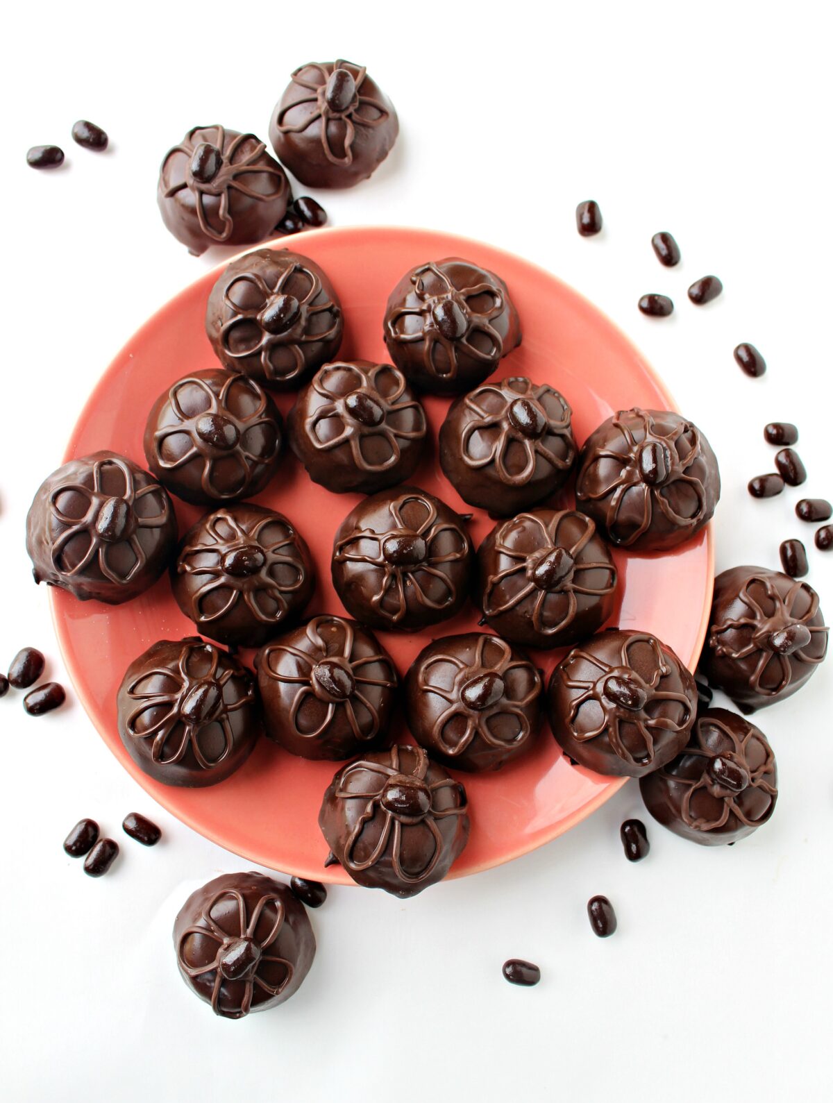 Bite sized Brownie Bites coated in chocolate with a chocolate piped flower design on top.