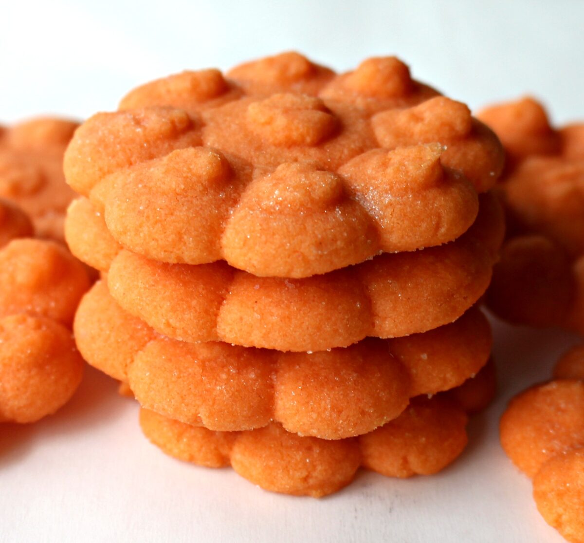 Stack of orange, pressed butter cookies.