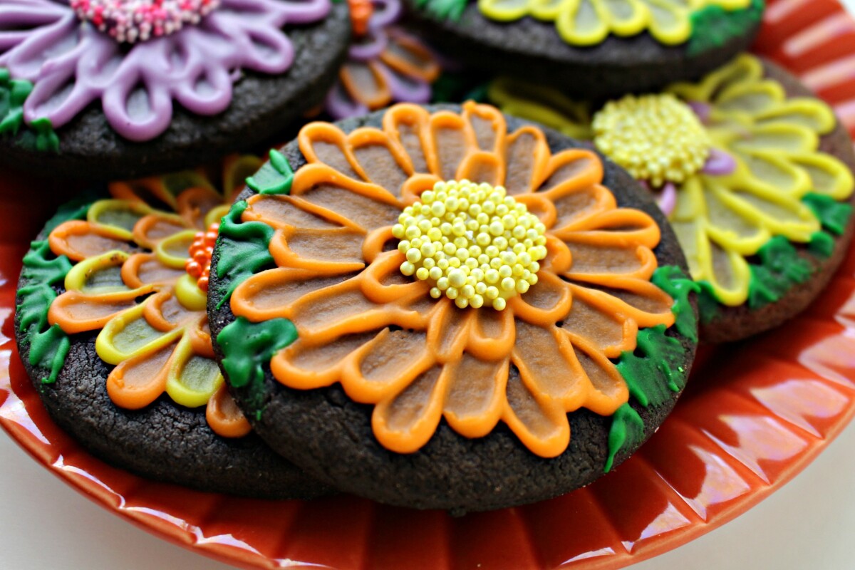 Closeup of an orange May Flowers Sugar Cookie on an orange plate. 