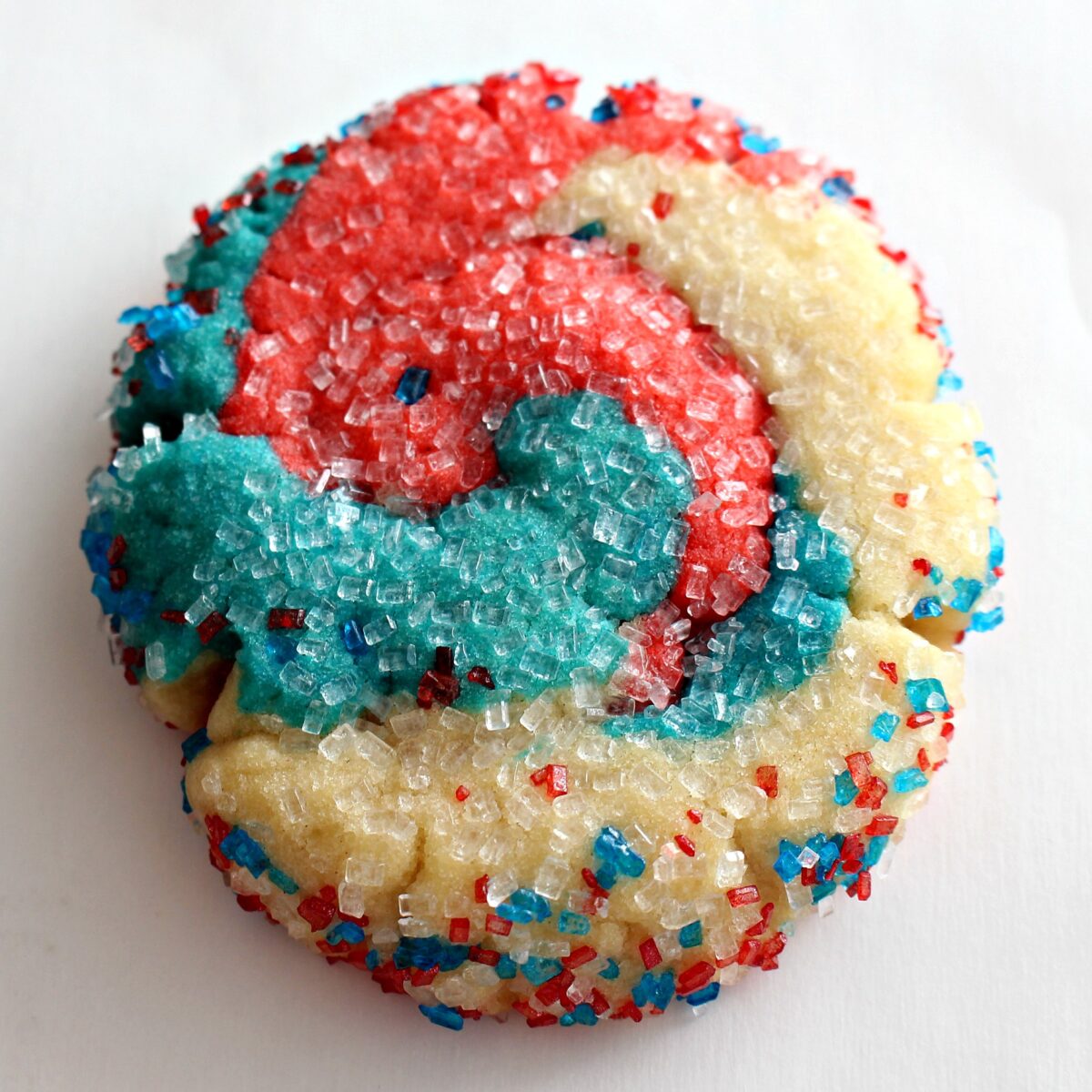 Closeup of a red, white, and blue sugar cookie coated in decorating sugar.