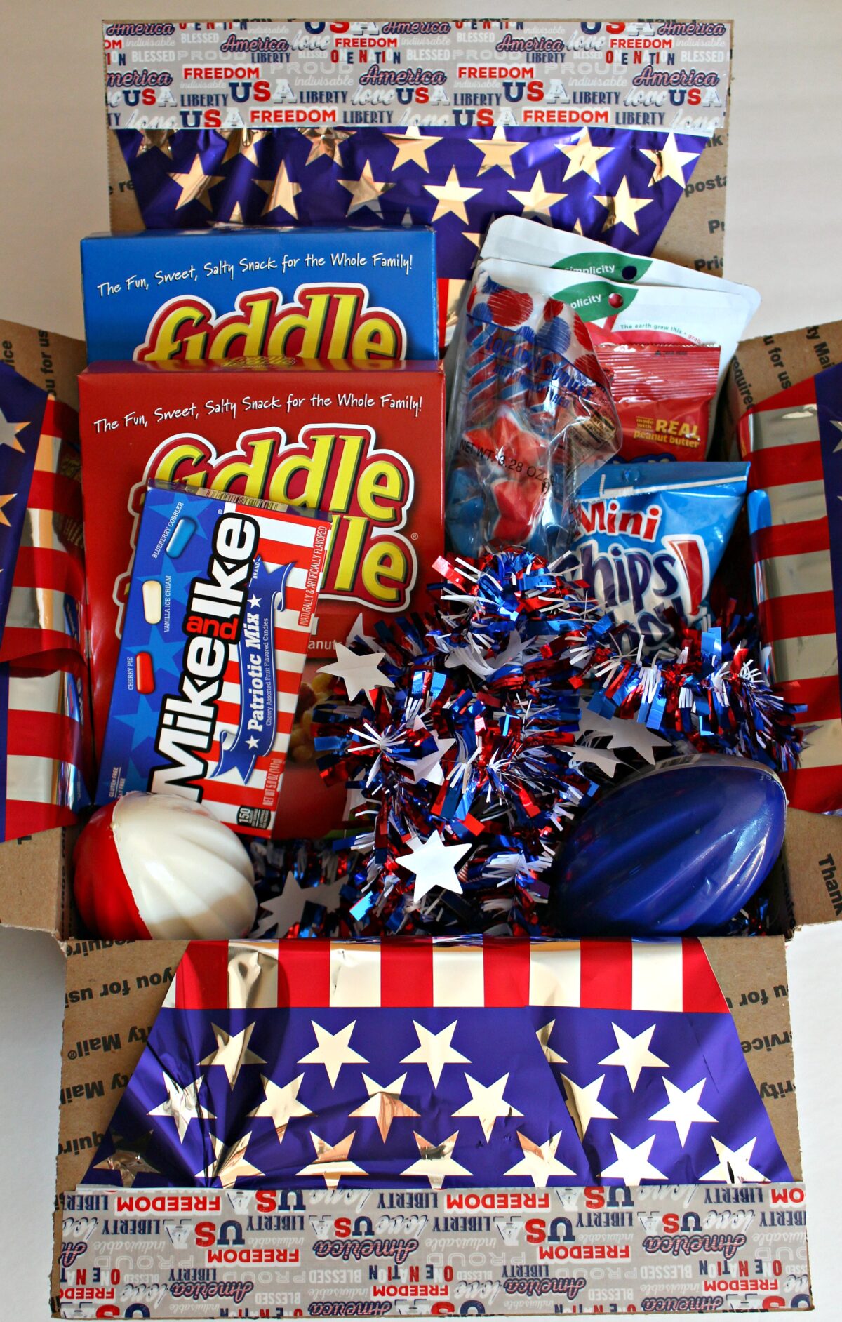 Decorated care package filled with treats packaged in red, white, and blue.