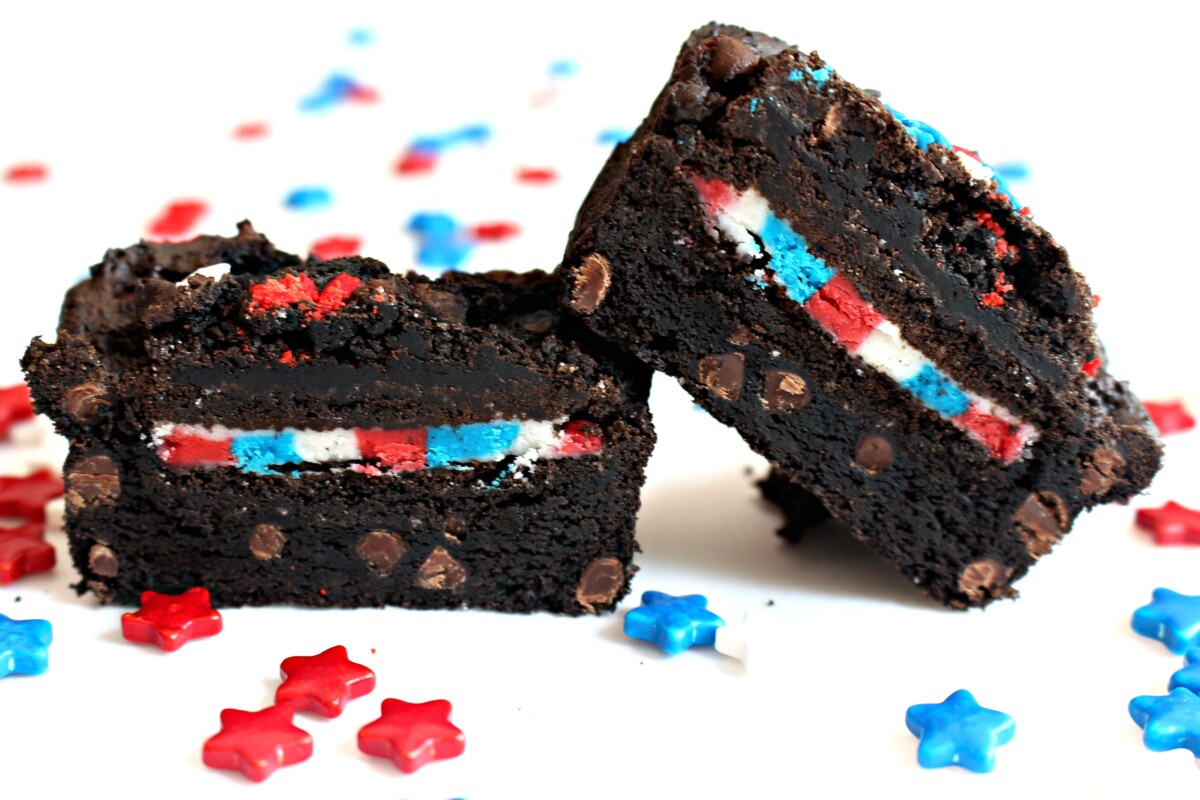 Sliced open brownie with an Oreo cookie in the middle, filled with red, white and blue frosting.