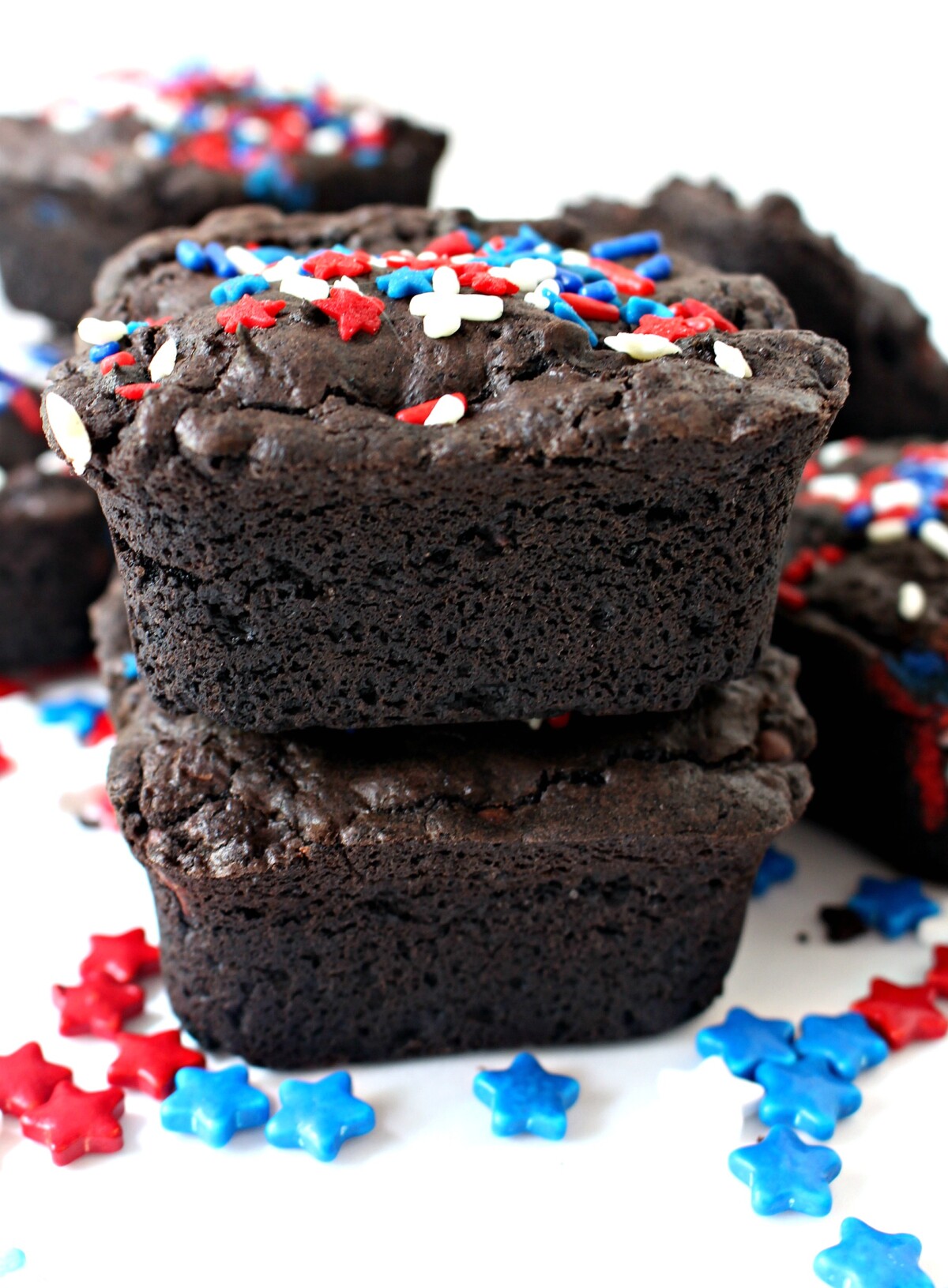 Stack of thick Fourth of July Brownies topped with red, white, and blue sprinkles.