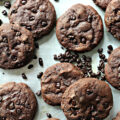 Closeup of flat chocolate cookies with cocoa nibs.