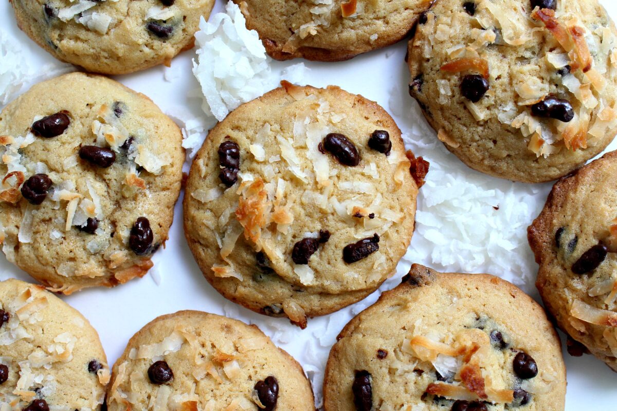 Overhead photo of Coconut Milk Cookies with shredded coconut and chocolate coated cocoa nibs on top.