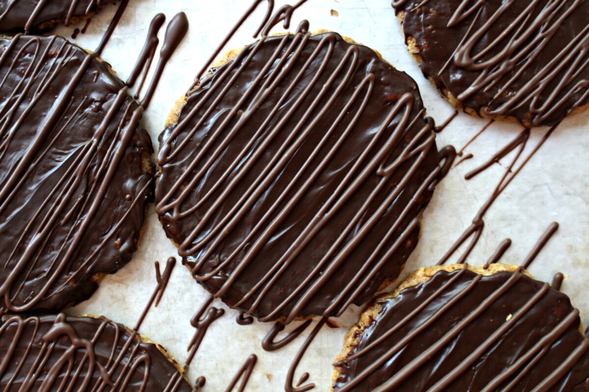 Cookies covered in chocolate then additional chocolate is zigzaged over the top.