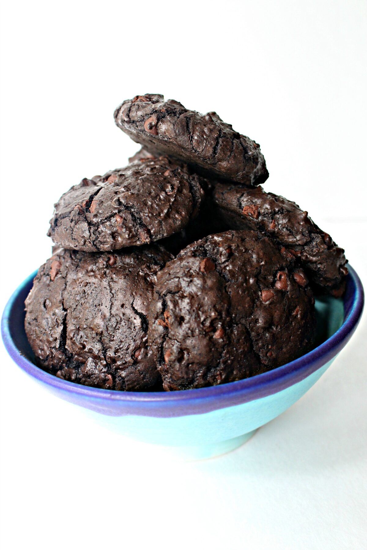 Thick, dark chocolate cookies piled in a blue bowl..