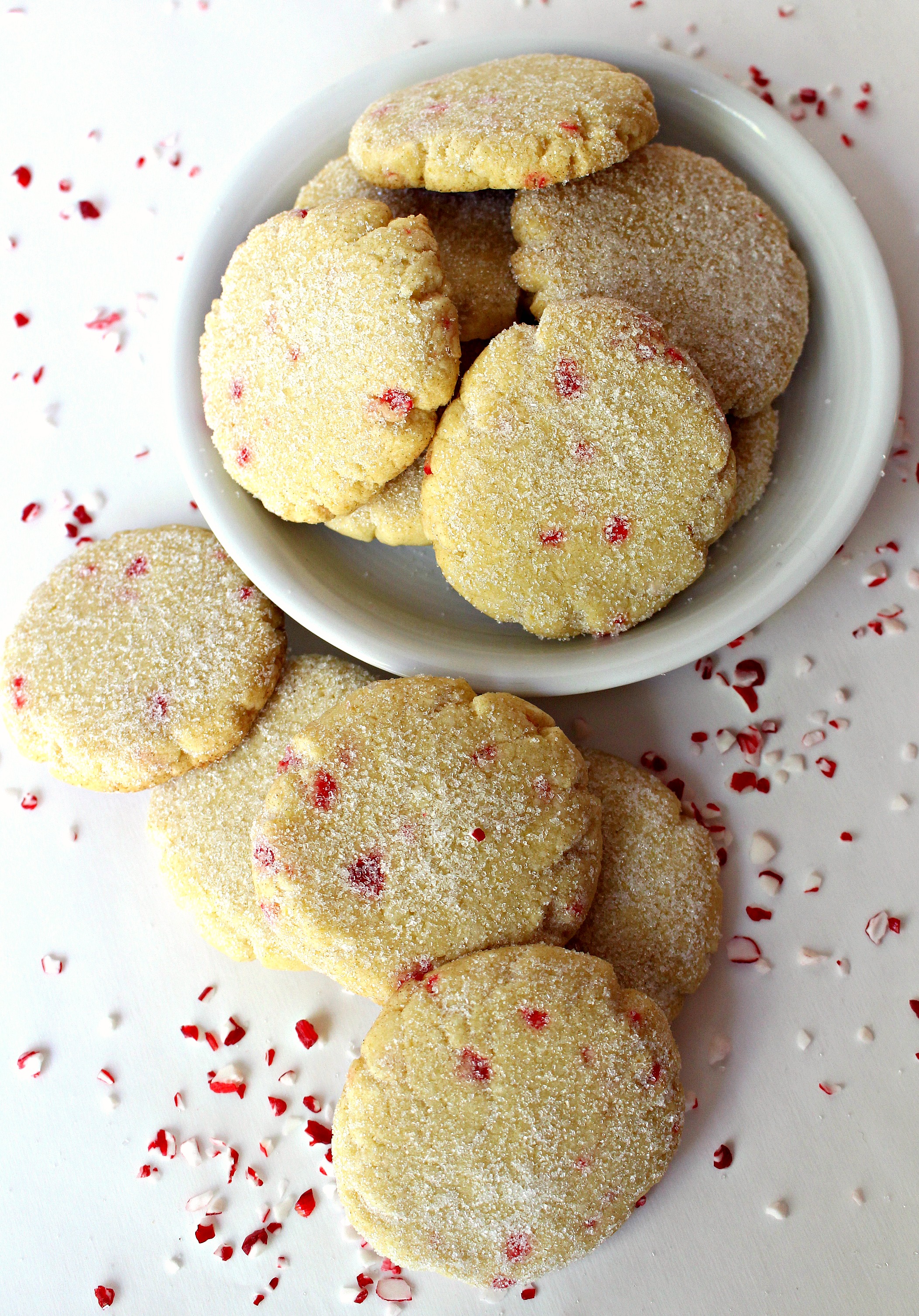 Round cookies speckled with pieces of peppermint candy and dusted with fine white sugar. 