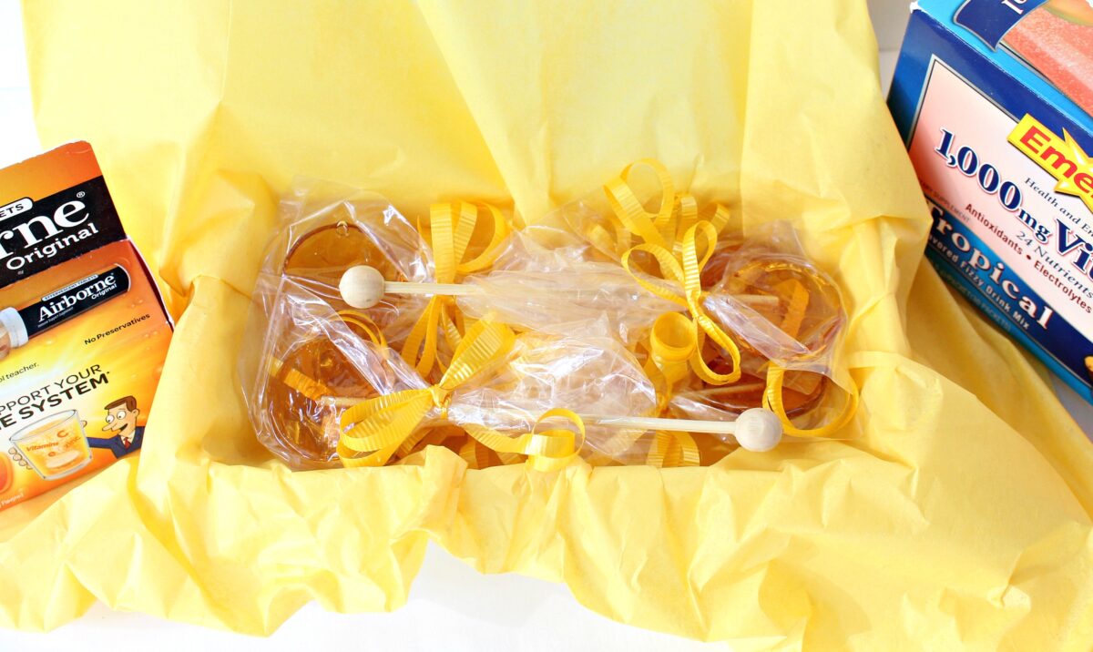 Lollipops  in a get well box lined with yellow tissue. 