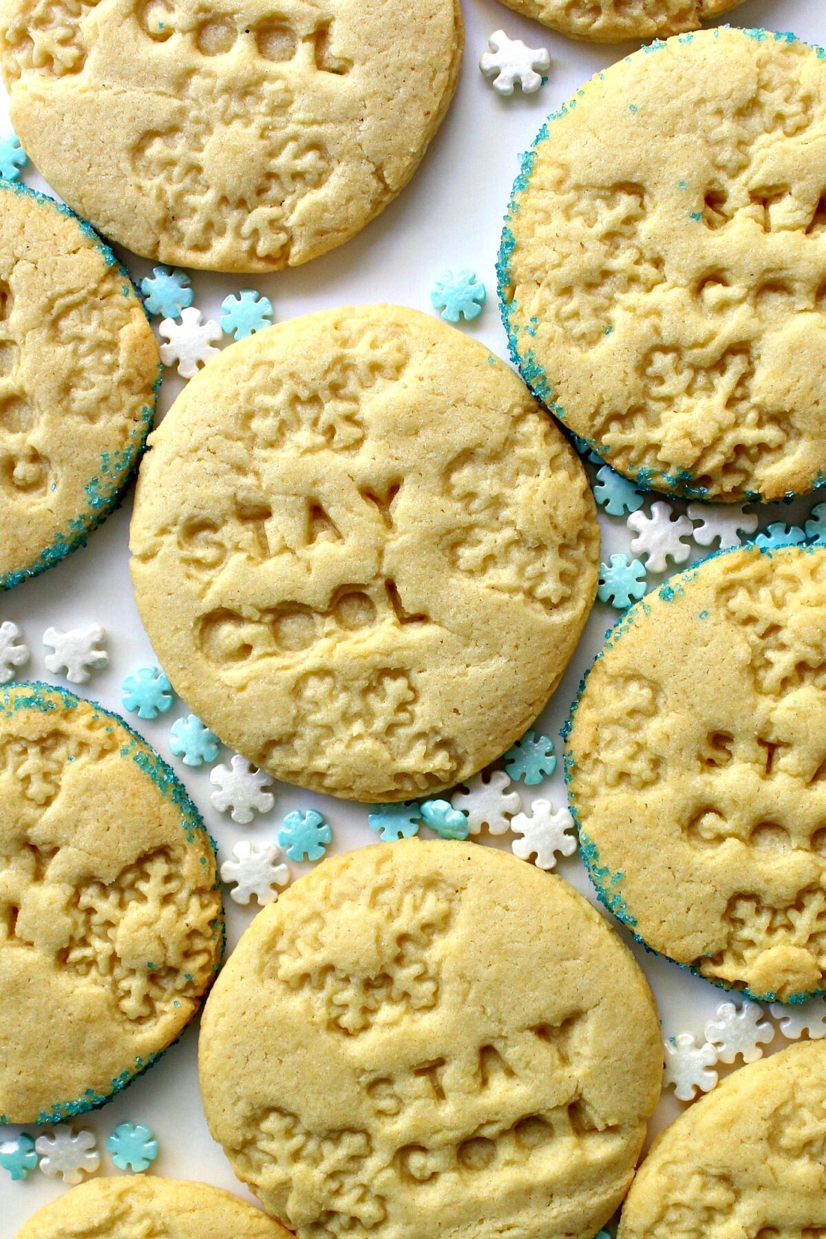 Round sugar cookies stamped with snowflakes and the words "stay cool".