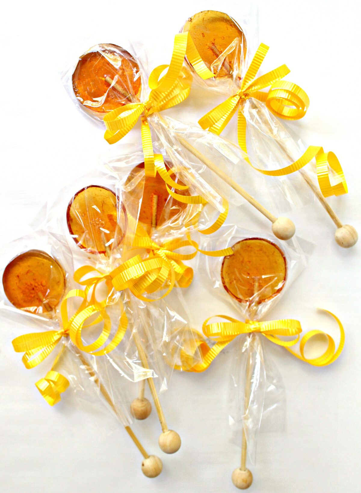 Honey Lollipops with cellophane bags over the candy, tied with a yellow ribbon.