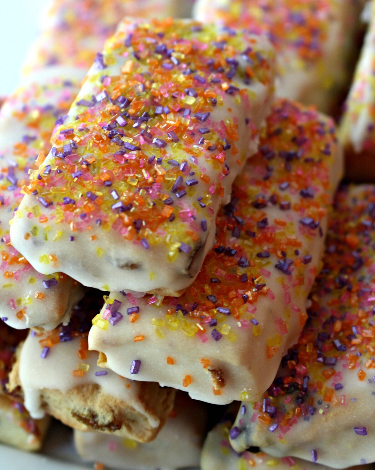 Closeup of stack of iced bar cookies topped with colorful decorating sugar.