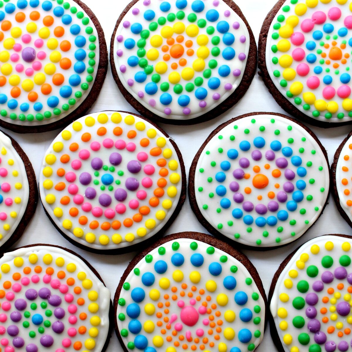 Dia de los Muertos Sugar Cookies with white icing, and circles of colorful icing dots.