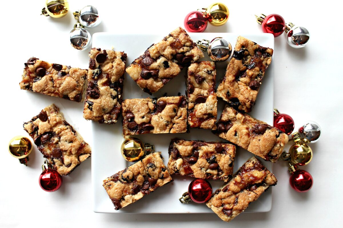 Cookie bars on a white serving plate with Christmas ornament balls.