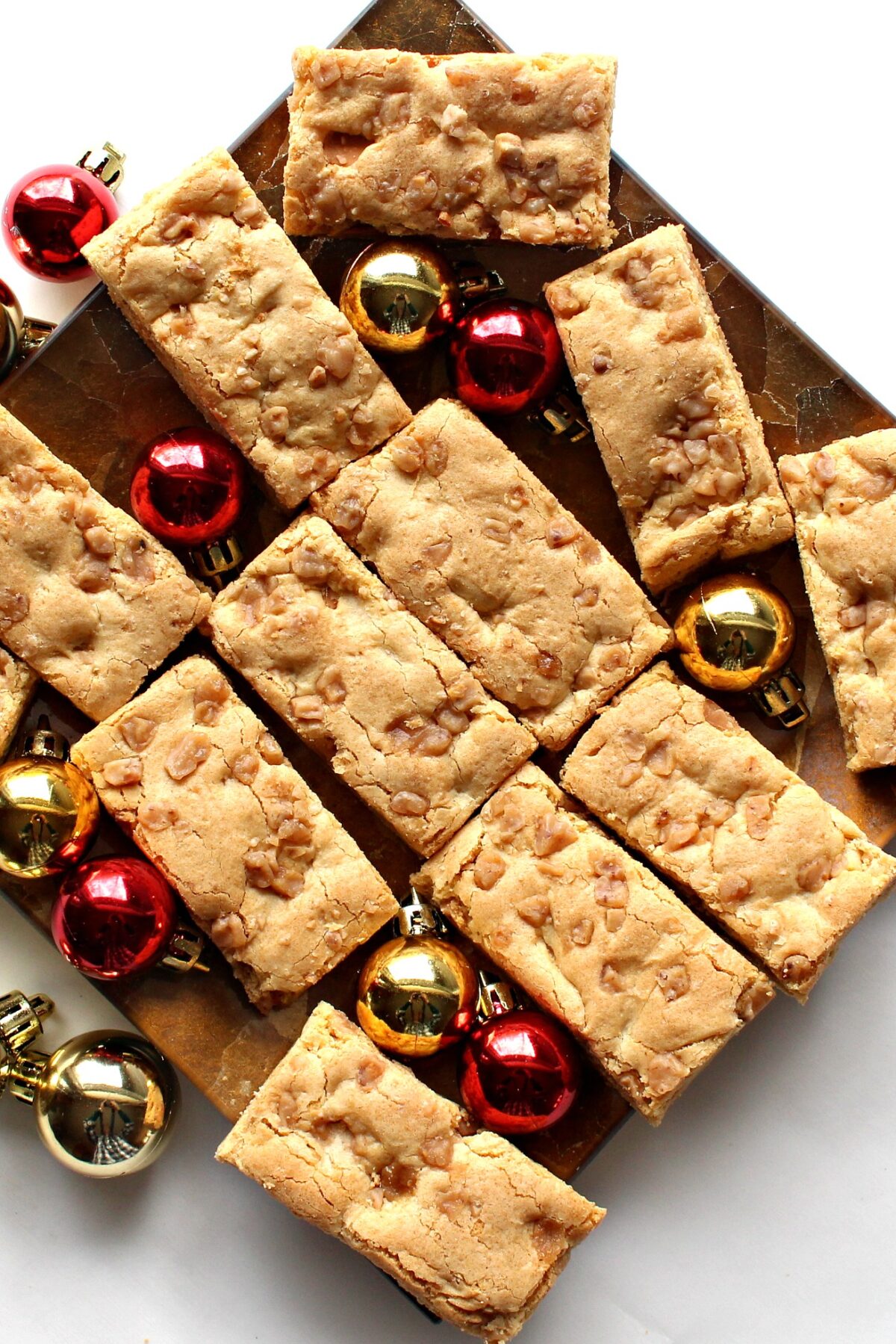 Blondie Bars  with butterscotch chips on a platter with Christmas ornament balls.