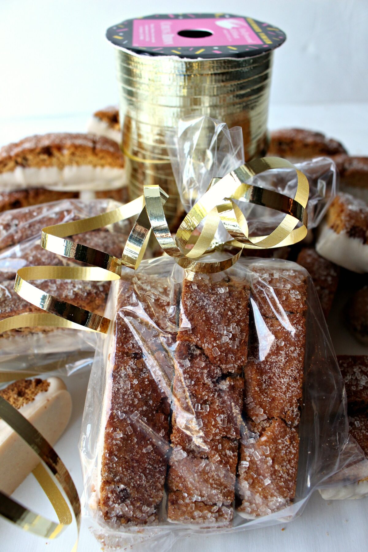 Biscotti wrapped for gifting in cellophane bags tied with gold ribbon.