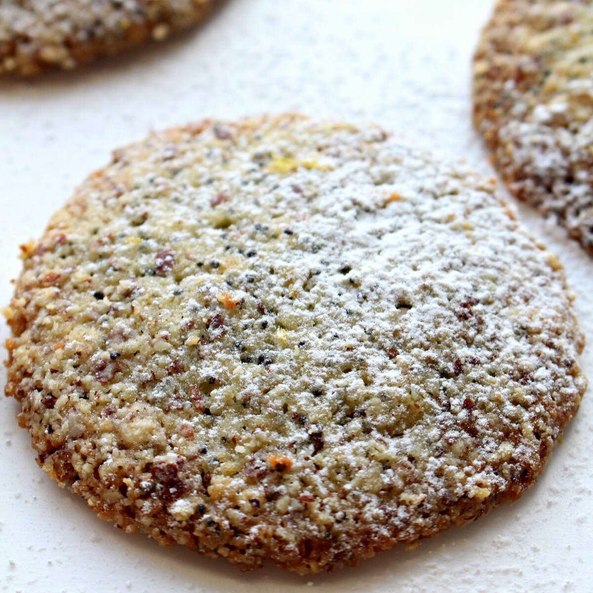 Closeup of  a Lemon Poppy Seed Cookie sprinkled with powdered sugar.