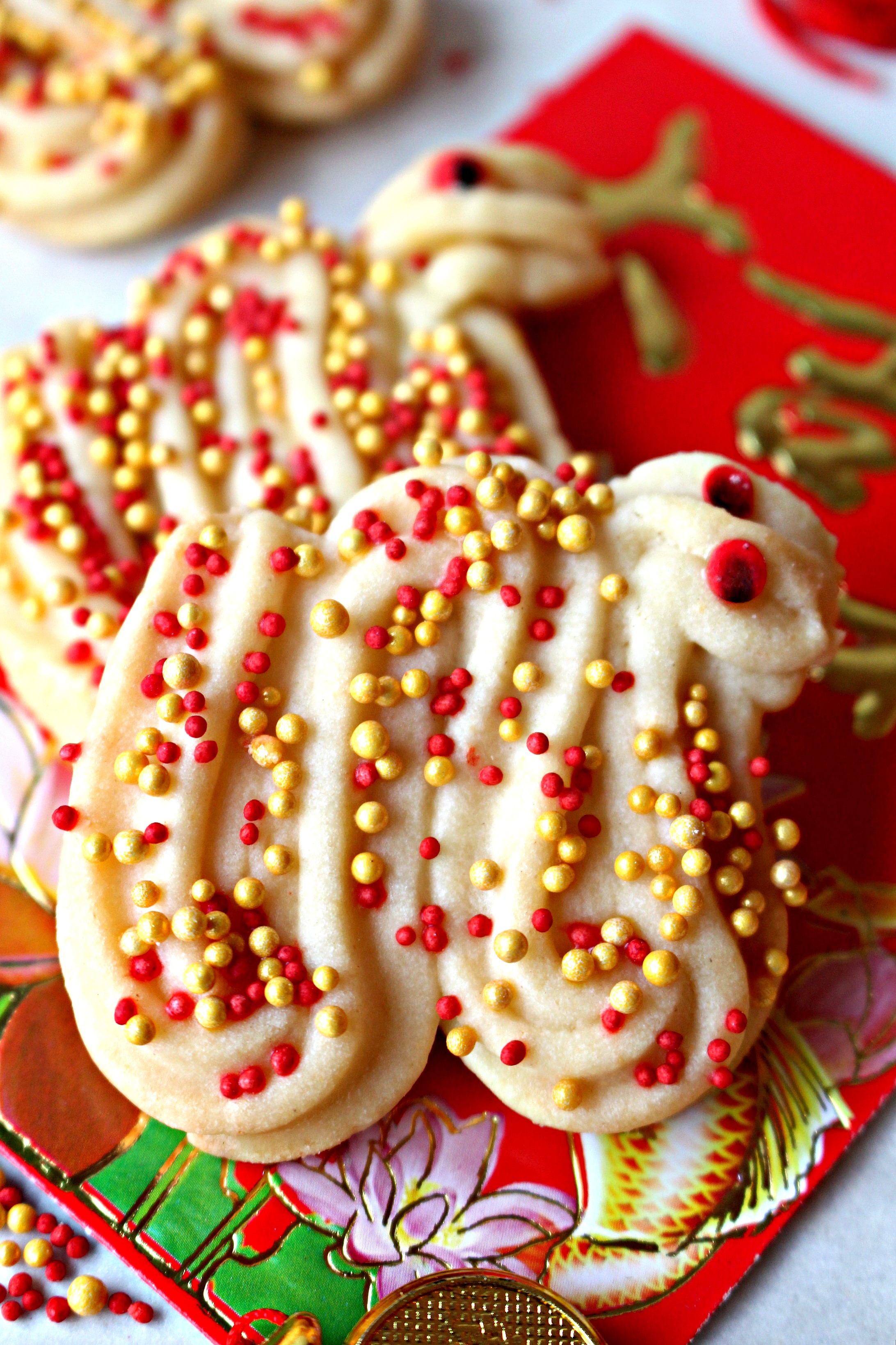 Butter Cookie Dragons made with piped butter cookie and sprinkled in red and gold.