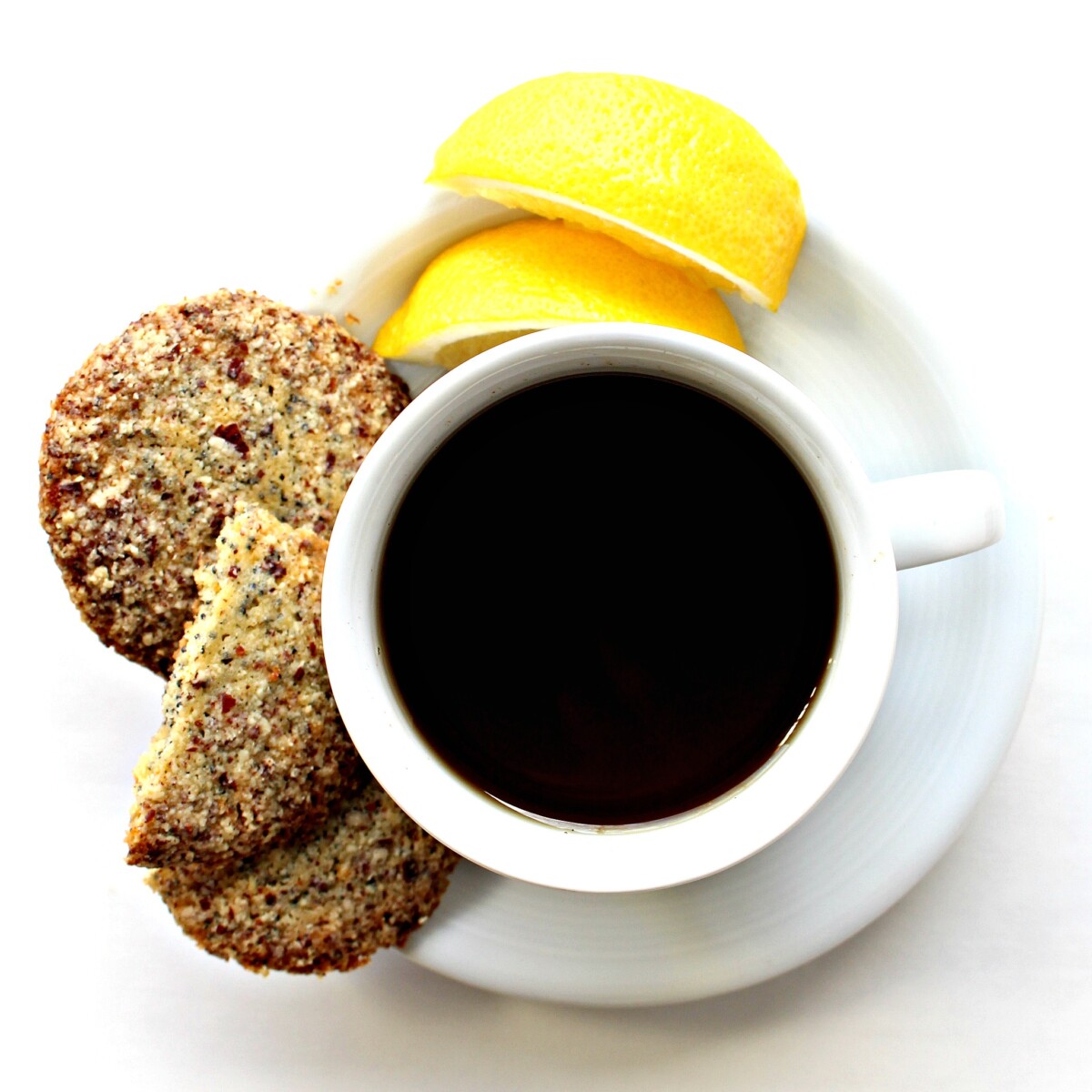 Overhead cup of tea with lemon slices and Lemon Poppy Seed Cookies on the saucer.