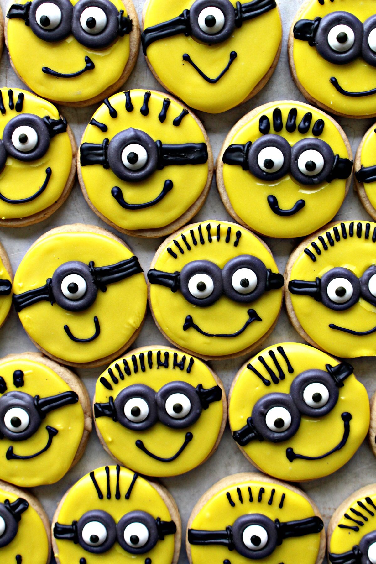 Minion Sugar Cookies with yellow faces and glasses with candy eyes.