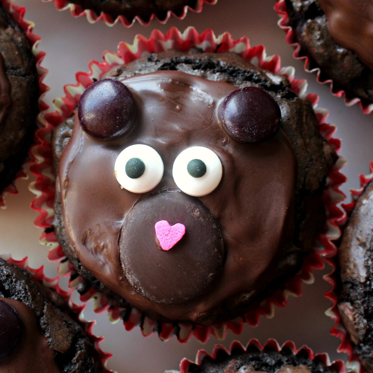 A close up of chocolate brownie cupcake decorated like a bear.