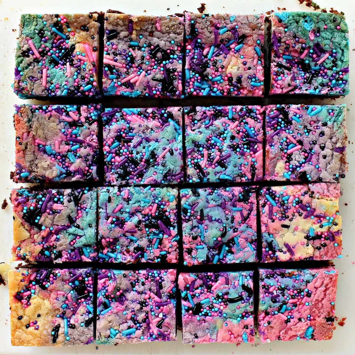 Galaxy Brownies topped with swirls of pink, blue and purple, cut into squares.