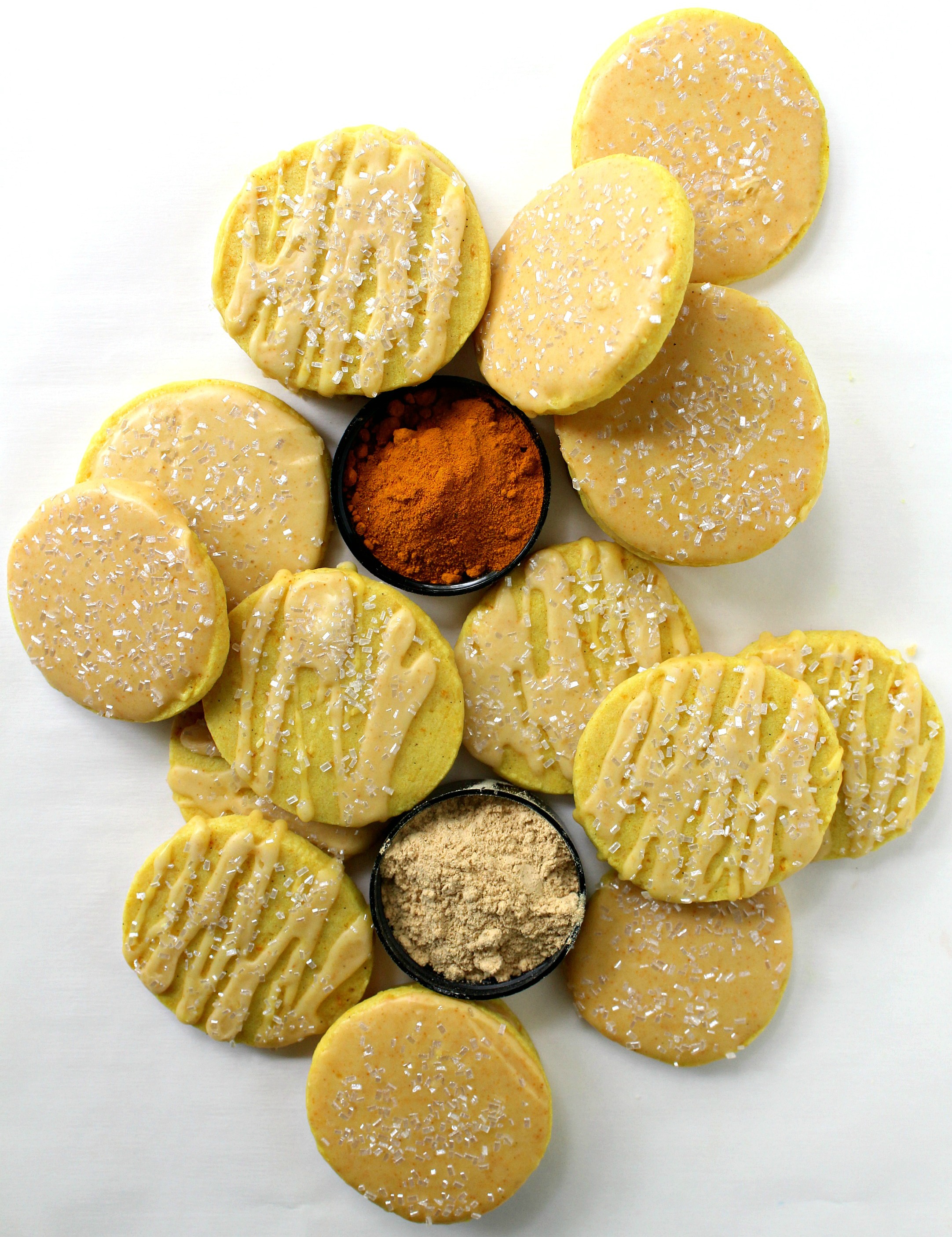 Iced, light yellow Turmeric Cookies on a white background.