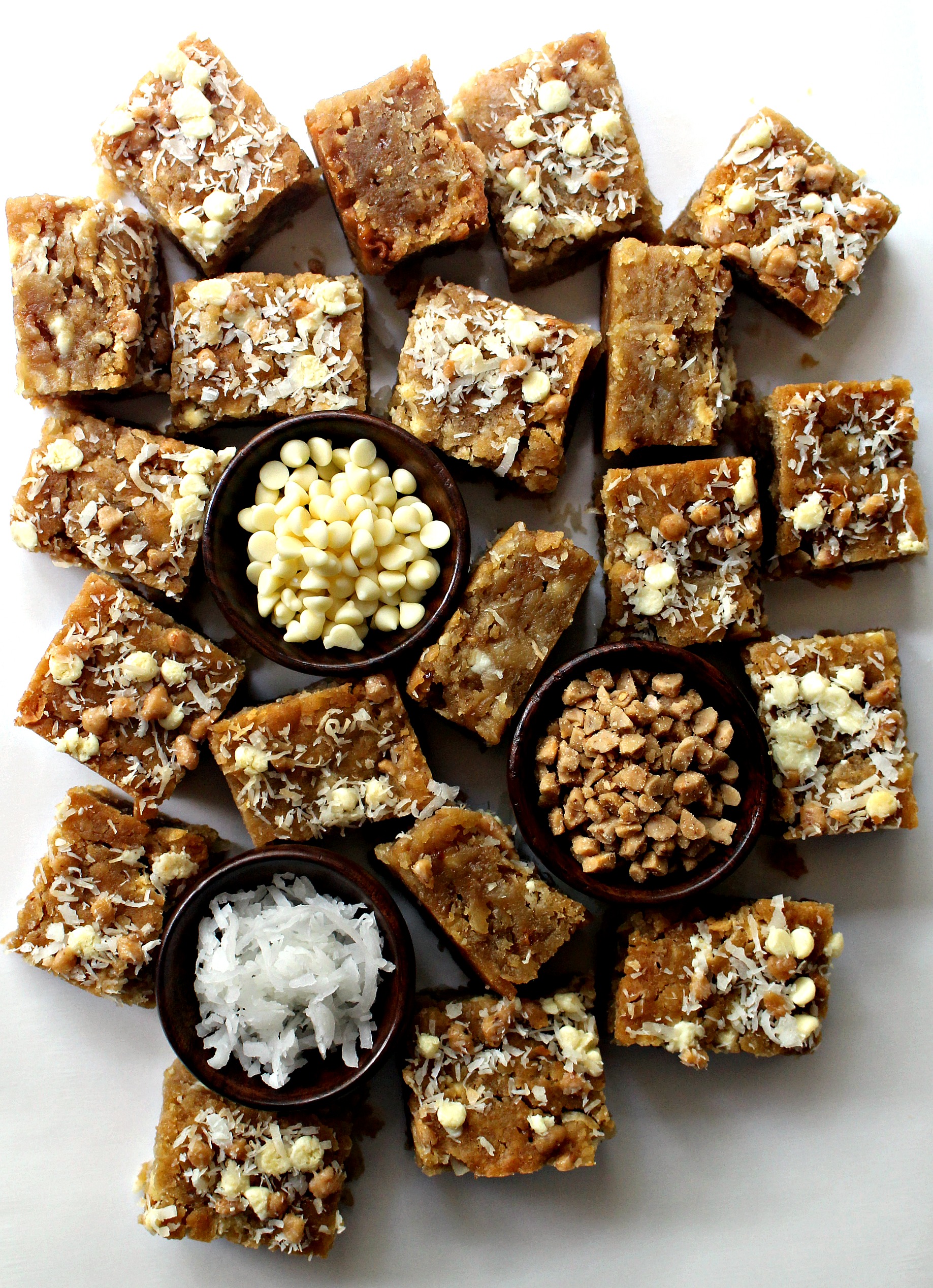 Coconut Milk Toffee Blondies with bowls of white chocolate chips, coconut, and toffee bits.