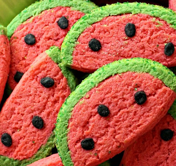 Closeup of Watermelon Sugar Cookies showing the details of the green edge, pink center, and black seeds.
