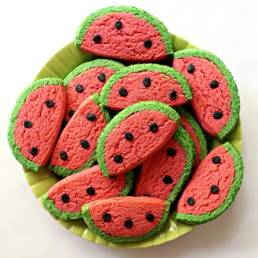 Half circle sugar cookies decorated to look like watermelon slices.