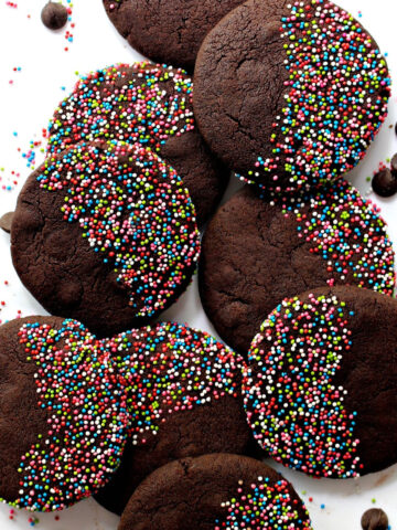 Dark brown chocolate cookies with muticolor nonpareil sprinkles.