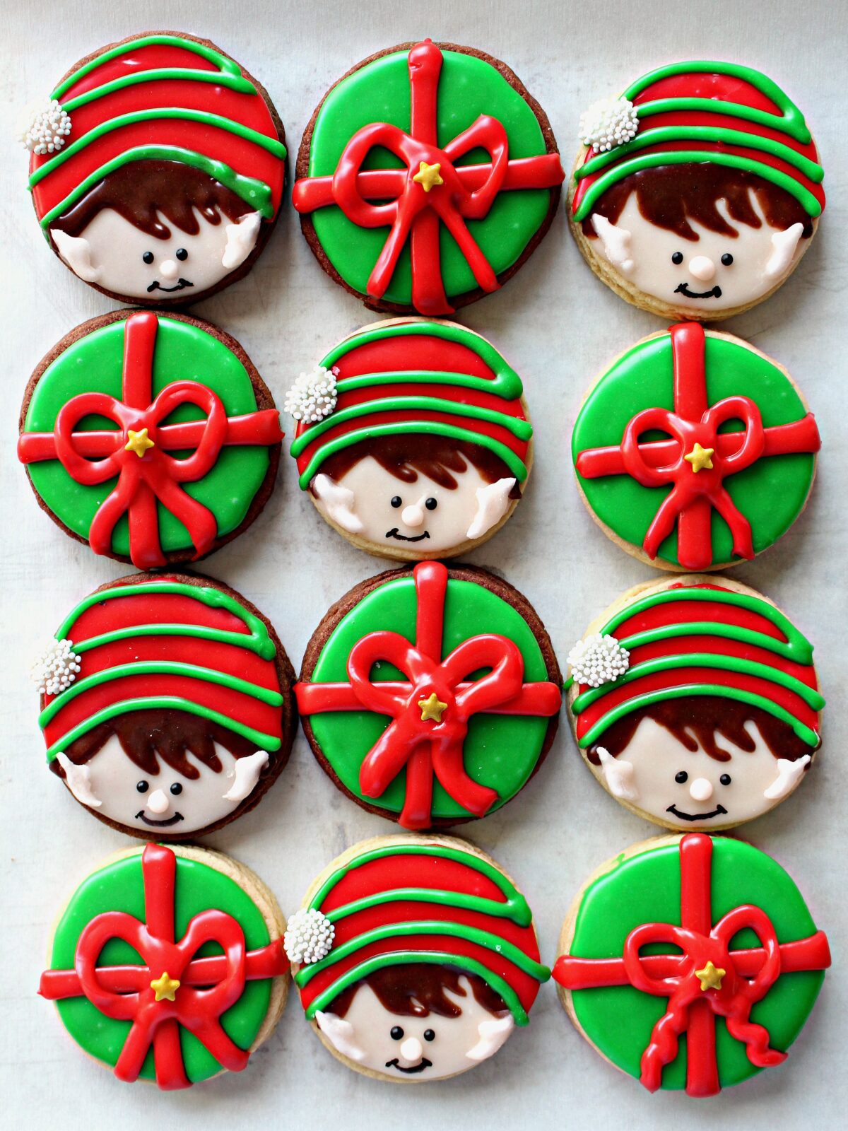 Sugar Cookies with decorated as elf on the shelf faces and wrapped gifts.