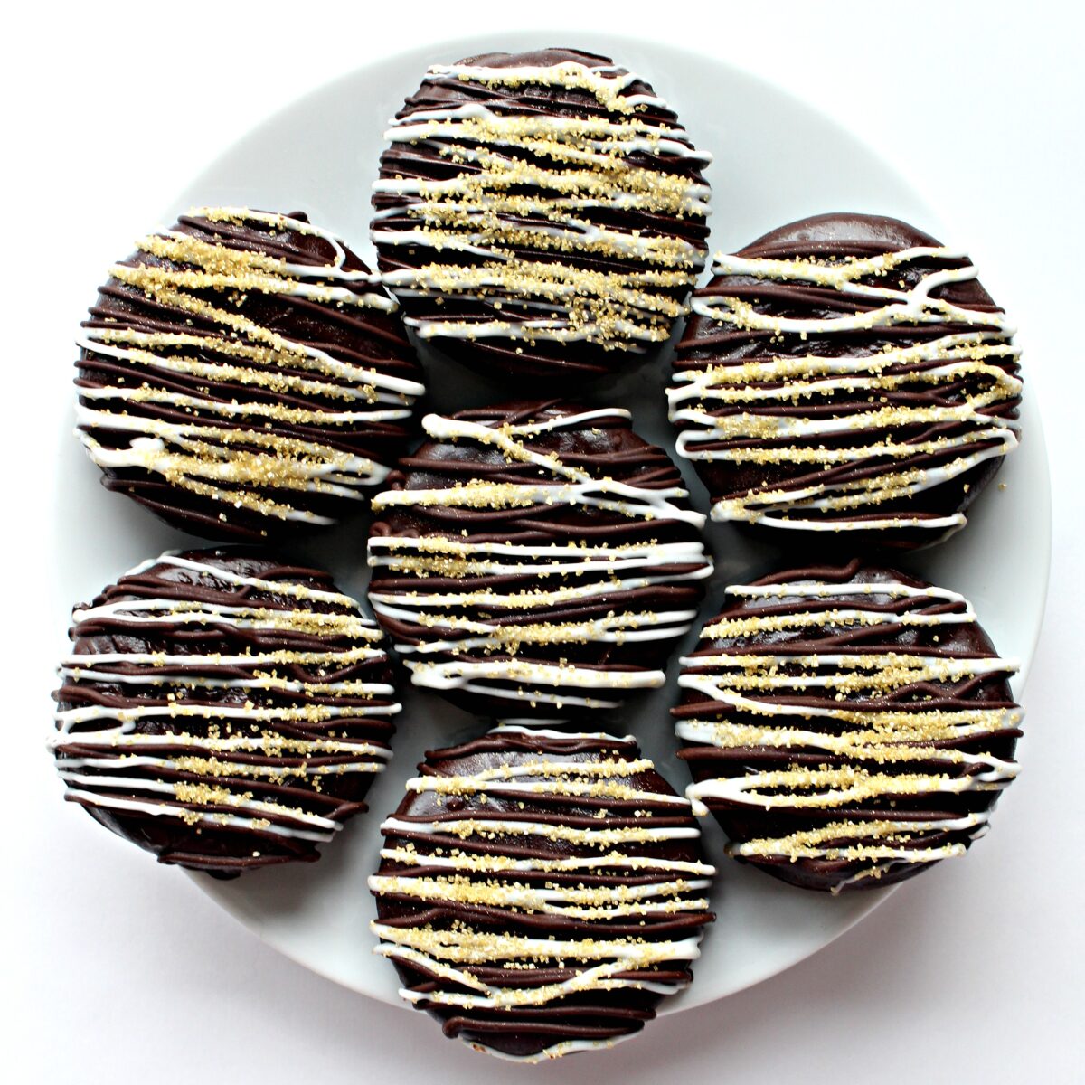  Chocolate Dipped Oreos topped with white chocolate drizzle and gold sugar.