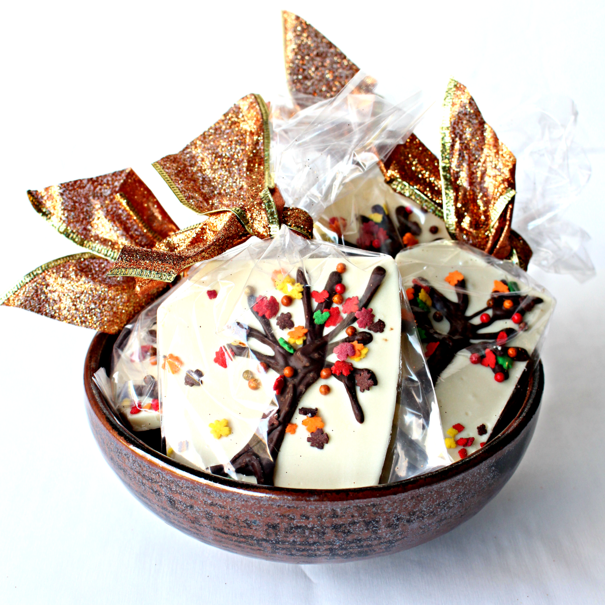 Pieces of Thanksgiving Chocolate Bark in a clear cellophane bags  tied with a sparkling gold ribbon. 