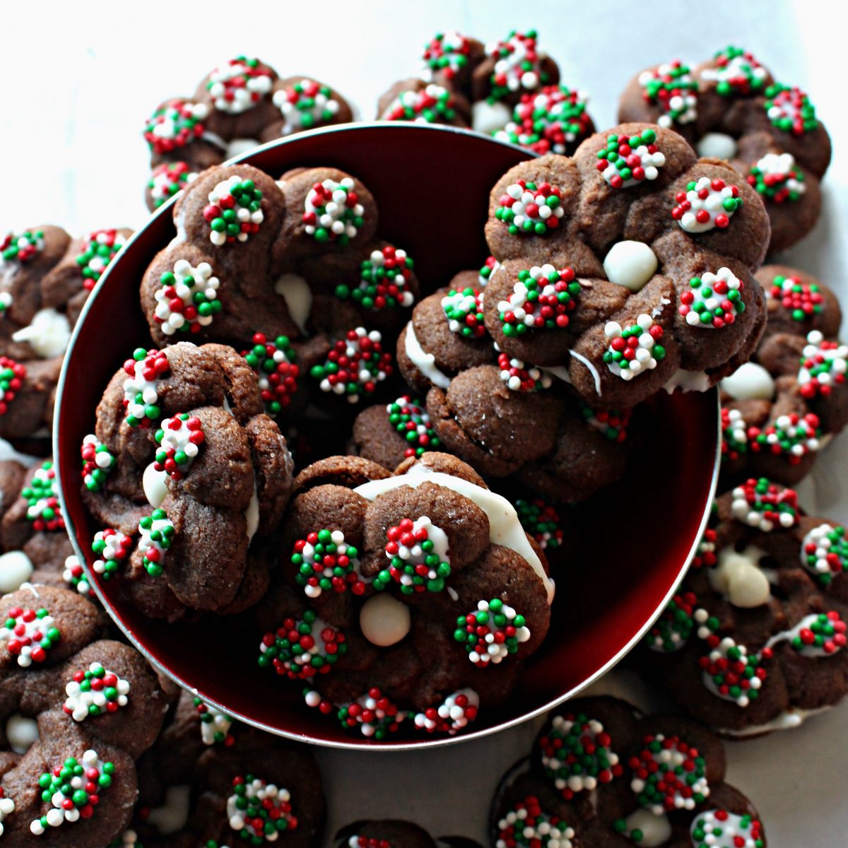 Bowl of Chocolate Espresso cookie wreaths, sandwiched with white chocolate, topped with red and green nonpareils.