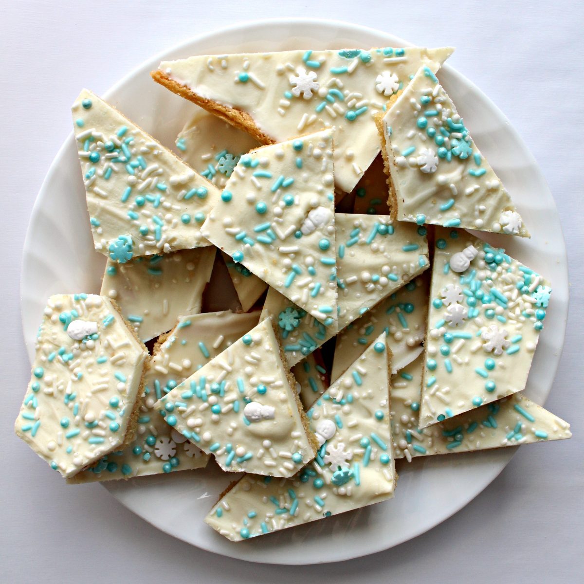 White chocolate Sugar Cookie Bark cut into individual serving pieces on a plate.