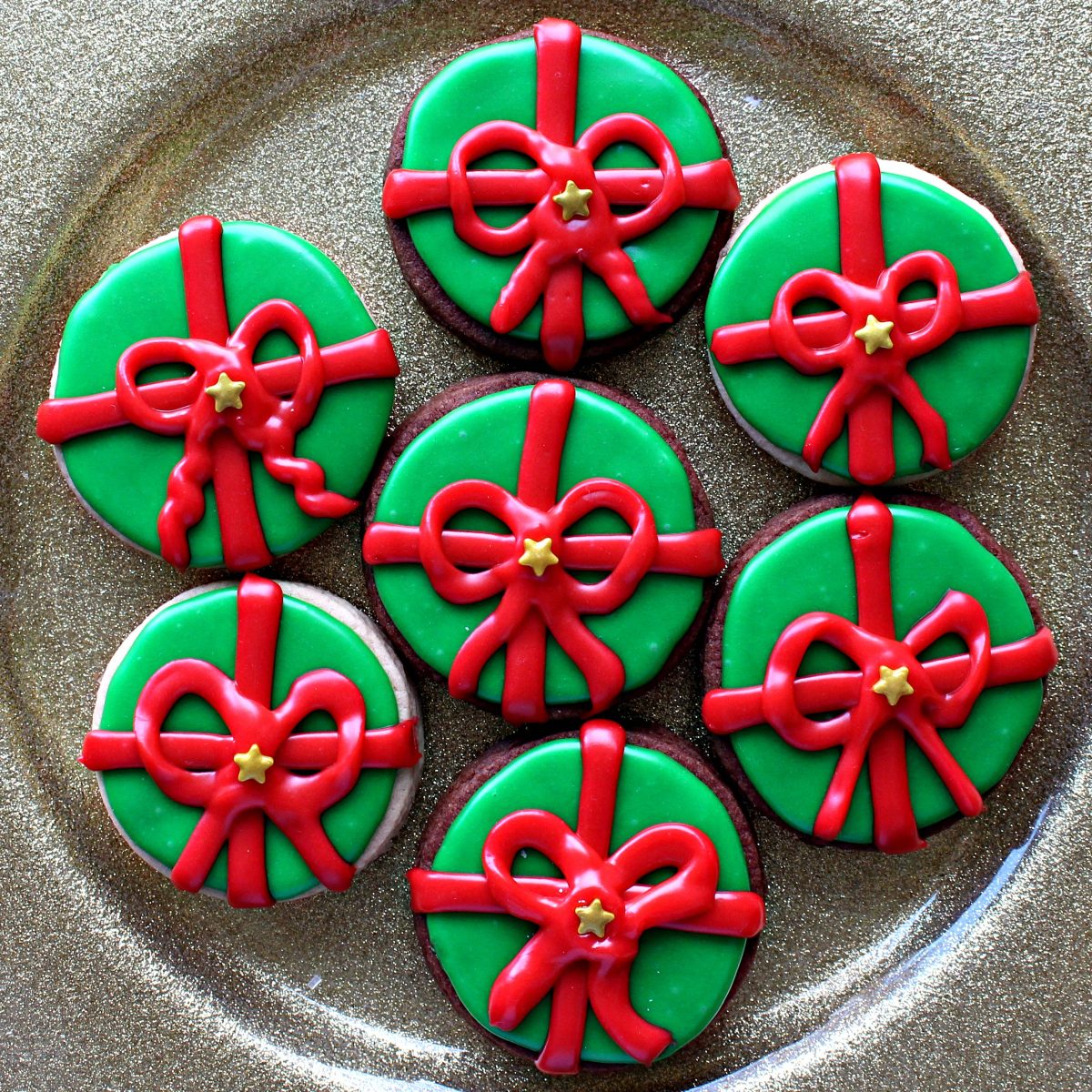 Gold plate with cookies decorated like wrapped gifts.