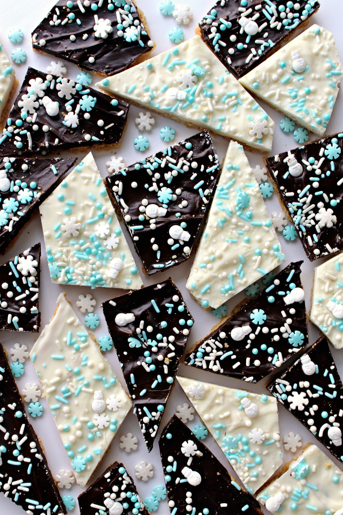 Sugar Cookie Bark with white or dark chocolate, decorated with white and blue snowflakes, snowmen,  sprinkles.